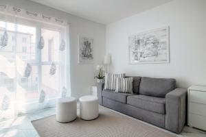 a white living room with a couch and a window at Il Parco 7 by Quokka 360 - in the business centre of Lugano in Lugano