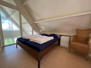 斯哈倫代克的住宿－Baken 8 persoons huis loopafstand Grevelingen Noordzee，一间小卧室,配有一张床和一把椅子