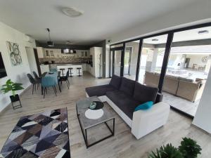 sala de estar con sofá y mesa en Solymos Apartmanház, en Vámosatya