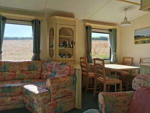 a living room with a couch and a table and chairs at Secluded Farmland Retreat - Valley View in Totnes