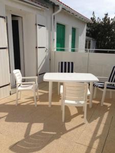 uma mesa branca e cadeiras sentadas num pátio em Vacances à la Tranche sur Mer em La Tranche-sur-Mer