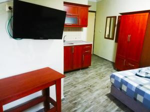 a room with a kitchen with a tv on the wall at Sagas Termal Butik Otel in Karahayit