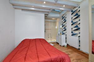 um quarto com uma cama vermelha num quarto em Les Herbages em Mers-les-Bains