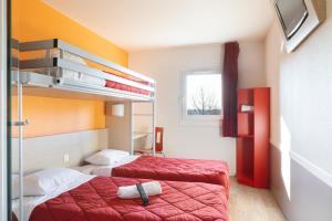 a hotel room with two beds and a window at Premiere Classe Maubeuge in Feignies