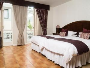 a large bedroom with a large bed with white sheets at Hotel Eberwein in Swakopmund