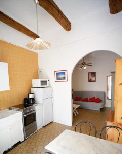 cocina y sala de estar con sofá en el fondo en 2EGA37 Studio en centre-ville, en Collioure