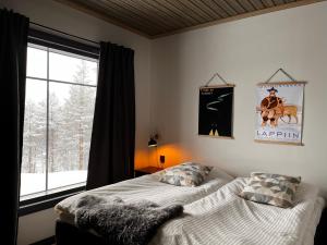 a bedroom with a bed and a window at Porthos Ski Lodge in Pyhätunturi