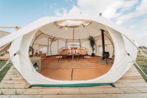Bamburgh Under Canvas في بامبورغ: خيمة فيها طاولة وكراسي