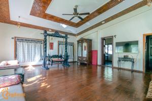 Ekayana Resorts and Agri Tourism, Mulshi في بيون: غرفة معيشة مع أرضيات خشبية وسقف