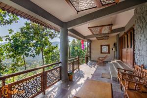 a balcony of a house with a table and chairs at Ekayana Resorts and Agri Tourism, Mulshi in Pune