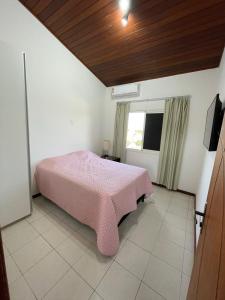 - une chambre avec un lit rose et une fenêtre dans l'établissement Casa Top Vilas, à Lauro de Freitas