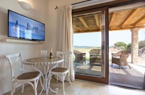 a dining room with a table and chairs and a television at Villa Nicoletta in Santa Teresa Gallura