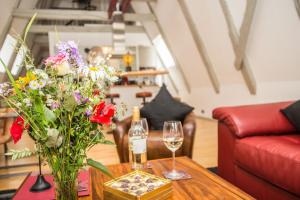 a table with a vase of flowers and a bottle of wine at Fleischhauerhof in Lübeck