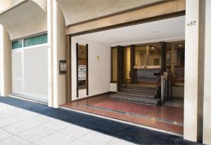 una entrada a un edificio con puertas de cristal y escaleras en Mercure Palermo Centro en Palermo