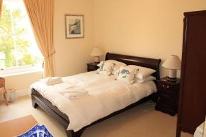 a bedroom with a bed with white sheets and pillows at Orchard View, Fowey in Fowey
