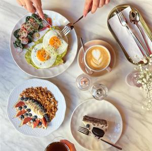 a table with three plates of food and a cup of coffee at Crystal Suites Old Town in Krakow