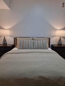 a bedroom with a bed with two nightstands and two lamps at Casa de Rosand in Cebu City