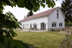 eine weiße Kirche mit einem Rasenplatz in der Unterkunft Landhofmühle in Eltendorf