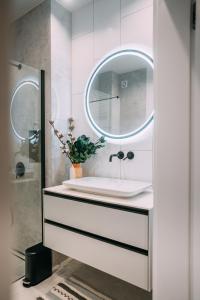 uma casa de banho com um lavatório e um espelho em Manufaktura Modern Industrial Apartment em Lódź