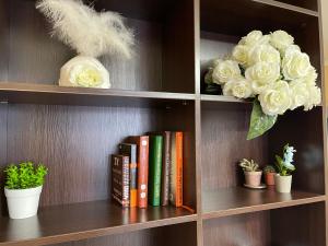 a book shelf with books and flowers and plants at Aq Shanyraq Atakent in Almaty