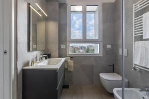 a bathroom with a sink and a toilet and a window at Bologna Tecnopolo Utamaro apartment in Bologna
