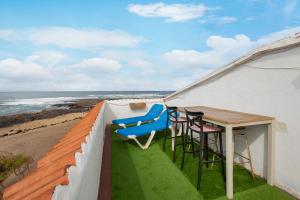 a balcony with a table and chairs and the ocean at El Cotillo Mar Beach in Cotillo