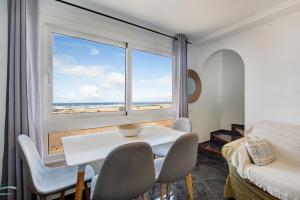 a room with a table and chairs and a large window at El Cotillo Mar Beach in Cotillo