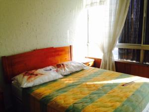 a bedroom with a bed with a colorful blanket at Depto Santiago San Miguel Metro Lo Vial in Santiago