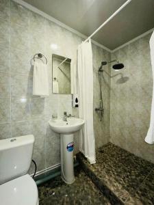 W łazience znajduje się umywalka, toaleta i prysznic. w obiekcie Apec Hotel w mieście Atyrau