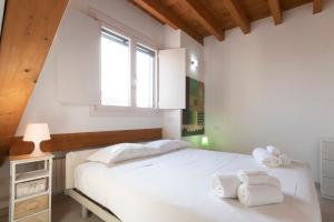 a bedroom with a white bed and a window at Mansarda Cola in Milan