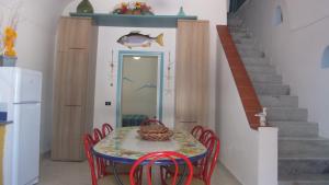 a dining room with a table and chairs and a staircase at Villa Glicine in Ponza
