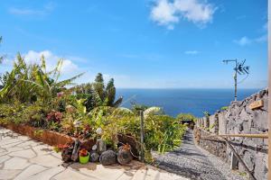 Los QuemadosにあるCasita Paraisoの植物と海を背景にした石道