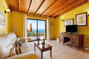 a living room with a couch and a tv at Casita Paraiso in Los Quemados