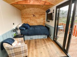 a small room with a bed and a chair at The Bumblebee in Pembroke