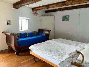 a living room with a blue couch and a bed at Casa Vecchia - Romantische Doppelhaushälfte mit spektakulärer Seesicht und 400 Jahre alten Gemäuern in Brione