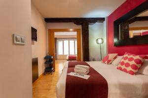 een slaapkamer met een groot bed met een rode muur bij Casual Arriaga in Bilbao