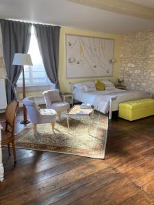 um quarto com uma cama grande e uma sala de estar em Le Patio Chambres et Tables d'Hôtes em La Tour-Blanche