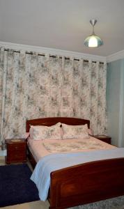 - une chambre avec un lit et un papier peint floral dans l'établissement Appartement idéal Riad Al salam à 8 minutes de la plage du centre ville,Wifi et parking gratuits, à Agadir