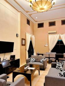ein Wohnzimmer mit Sofa und Fernseher in der Unterkunft A'Famosa Villa V5 Garden Home Pool Villa Melaka in Kampong Alor Gajah + 15 Fotos