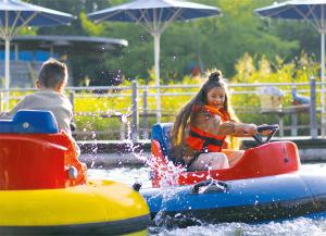 a young girl and boy riding on a water slide at Ravensburger Spieleland Feriendorf in Meckenbeuren