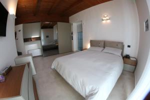 a bedroom with a large white bed and a mirror at Mirko's house in Licata