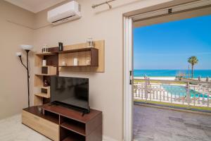 a living room with a television and a view of the ocean at Cinque Terre - Ionio in Zakynthos Town