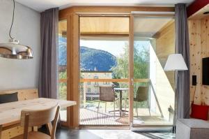 a room with a dining table and a large window at Alpine Lodge 2-Bett-Wohnung Chesa Plattner "Bergbahnen All inklusiv" im Sommer in Pontresina