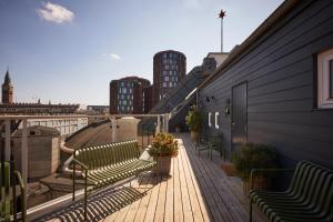 a balcony with benches and a view of a city at Hypernym Hotel & Suites in Copenhagen