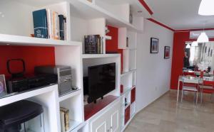 sala de estar con estanterías blancas y TV en La Farola Centro de Málaga con Parking 445 Max, en Málaga