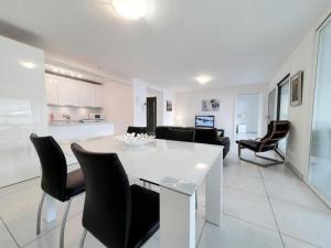 uma cozinha e sala de estar com uma mesa branca e cadeiras em Süsse Wohnung mit bezaubernde Seesicht Apt 405 em Locarno