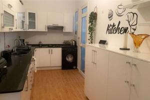 a kitchen with white cabinets and a sink and a dishwasher at Outstanding Two bedroom Apartment in Sahline