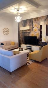a living room with two white couches and a tv at Outstanding Two bedroom Apartment in Sahline