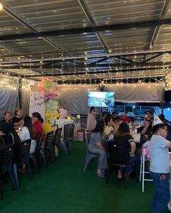 a group of people sitting in chairs at a party at EUC Room Stay in Tuaran