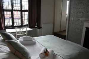 a bedroom with a bed with towels on it at The Lady Elizabeth in Sudbury